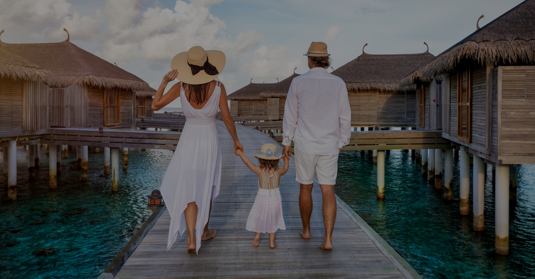 A family on an overwater villa walkway